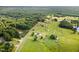 Expansive aerial view of a lush property featuring multiple homes, outbuildings, ponds and verdant pastures at 457 Poplar Forest Ln, Pittsboro, NC 27312