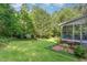 Green backyard with mature trees, a fire pit, and a patio area for relaxation and entertaining at 457 Poplar Forest Ln, Pittsboro, NC 27312