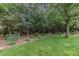 Serene backyard featuring a well-maintained lawn surrounded by mature trees at 457 Poplar Forest Ln, Pittsboro, NC 27312