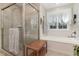 Bright bathroom featuring a tiled shower, soaking tub, and large window with sheer curtains at 457 Poplar Forest Ln, Pittsboro, NC 27312