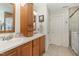 Spacious bathroom with double vanity, framed mirrors, wooden cabinets, and shower with glass door at 457 Poplar Forest Ln, Pittsboro, NC 27312