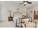 Bedroom featuring a metal frame bed, ceiling fan, and a decorative seating area at 457 Poplar Forest Ln, Pittsboro, NC 27312