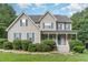 Charming two-story home with a cozy front porch, blue shutters, and meticulously landscaped front yard at 457 Poplar Forest Ln, Pittsboro, NC 27312