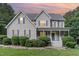 Charming two-story home with a cozy front porch, blue shutters, and meticulously landscaped front yard at 457 Poplar Forest Ln, Pittsboro, NC 27312