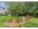 Beautiful home with a lush green lawn and a decorative brick-bordered garden at 457 Poplar Forest Ln, Pittsboro, NC 27312