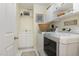 Well-organized laundry room with white cabinets, sink, and modern washer and dryer set at 457 Poplar Forest Ln, Pittsboro, NC 27312