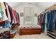 Spacious walk-in closet with clothing racks, window, wooden bench, and ample storage at 457 Poplar Forest Ln, Pittsboro, NC 27312