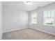Bright bedroom with neutral walls, plush carpeting, and dual windows creates an airy, inviting space at 4940 Enlightenment Rd, Raleigh, NC 27616