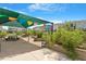Charming community garden with raised beds, picnic tables, shade structure, and colorful pennant flags overhead at 4940 Enlightenment Rd, Raleigh, NC 27616