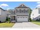 Charming two-story home boasts a manicured lawn, gray siding, shutters, and a two-car garage at 4940 Enlightenment Rd, Raleigh, NC 27616