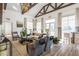 Sunlit living room with vaulted ceilings, wood beams, fireplace, and luxury decor at 4940 Enlightenment Rd, Raleigh, NC 27616
