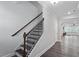 Modern staircase with dark wood treads and white trim, leading to the upper level at 4940 Enlightenment Rd, Raleigh, NC 27616