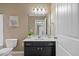 This bathroom features a vanity with a dark cabinet, a framed mirror and a floral art piece at 504 Gumview Cir, Fuquay Varina, NC 27526