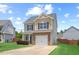 Charming two-story home with a manicured lawn, stone accents, and an attached one car garage at 504 Gumview Cir, Fuquay Varina, NC 27526