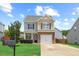 Charming two-story home with a manicured lawn, stone accents, and an attached one car garage at 504 Gumview Cir, Fuquay Varina, NC 27526