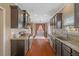 Long kitchen view features granite countertops, stainless steel appliances, and dark wood floors at 504 Gumview Cir, Fuquay Varina, NC 27526