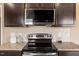 Close up on a kitchen with granite countertops and dark cabinets, highlighting modern appliances at 504 Gumview Cir, Fuquay Varina, NC 27526
