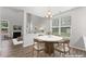 An open-concept dining area with a modern chandelier and a view of the living room and fireplace at 515 Historic Dr, Hillsborough, NC 27278