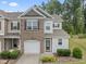 Charming townhome features a front-entry garage, brick accents, and manicured landscaping at 515 Historic Dr, Hillsborough, NC 27278