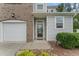 A close-up view of the front entrance of the townhome with a glass door and attached garage at 515 Historic Dr, Hillsborough, NC 27278
