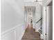 An inviting hallway with wood floors, white wainscoting, and a staircase leading to the upper level at 515 Historic Dr, Hillsborough, NC 27278