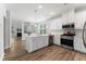 A modern kitchen with white cabinets, stainless steel appliances, and a large center island at 515 Historic Dr, Hillsborough, NC 27278