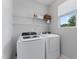 Modern laundry room with white washer and dryer, and wire shelving at 515 Historic Dr, Hillsborough, NC 27278