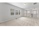 Upstairs loft area with three bright windows, neutral carpet, and a view of the staircase at 515 Historic Dr, Hillsborough, NC 27278