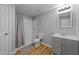 Bathroom featuring a single sink vanity, toilet, shower with curtains and wood-look floors at 541 Mallie Pearce Rd, Zebulon, NC 27597