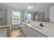 Bright bathroom with dual sinks, framed mirror, a window, and a walk-in shower at 541 Mallie Pearce Rd, Zebulon, NC 27597