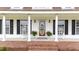 Charming front porch with white pillars and rocking chairs gives a warm welcome at 541 Mallie Pearce Rd, Zebulon, NC 27597