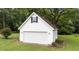 View of a detached two-car garage with white siding, black shutters, and well manicured lawn at 541 Mallie Pearce Rd, Zebulon, NC 27597