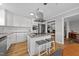 Bright kitchen features white cabinets, stainless steel appliances, a granite island, and hardwood floors at 541 Mallie Pearce Rd, Zebulon, NC 27597