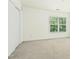 Spacious bedroom with a large window and neutral carpet at 5545 Crabtree Park Ct, Raleigh, NC 27612