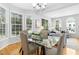 Dining area with a glass table, hardwood floors, and abundant natural light at 5545 Crabtree Park Ct, Raleigh, NC 27612