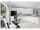 Updated kitchen featuring white cabinetry, black appliances, and a glass top table at 5545 Crabtree Park Ct, Raleigh, NC 27612