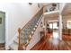 Bright foyer featuring hardwood floors, staircase with carpet runner, and an open view into the living area at 5920 Two Pines Trl, Wake Forest, NC 27587