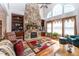 Bright living room featuring built in bookcases, a stone fireplace, ceiling fan, and large arched windows at 5920 Two Pines Trl, Wake Forest, NC 27587