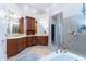Main bathroom with double sinks, wooden cabinetry, a glass shower and soaking tub at 5920 Two Pines Trl, Wake Forest, NC 27587