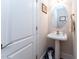 A powder room featuring a pedestal sink, mirror and door to toilet at 5920 Two Pines Trl, Wake Forest, NC 27587