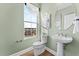 Elegant powder room with pedestal sink, modern fixtures, decorative mirror, and a window at 600 Hedrick Ridge Road # 310 209, Cary, NC 27519