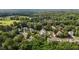 Aerial view showcasing homes in a verdant neighborhood surrounded by lush trees at 603 Everglades Dr, Mebane, NC 27302