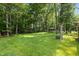 Expansive backyard featuring mature trees, and a trampoline, perfect for outdoor activities at 603 Everglades Dr, Mebane, NC 27302