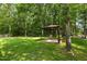 Expansive backyard featuring mature trees, and a charming gazebo perfect for relaxation at 603 Everglades Dr, Mebane, NC 27302