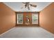Bedroom with orange walls, light carpet, and two bright windows at 603 Everglades Dr, Mebane, NC 27302