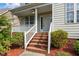Inviting front porch with brick steps, white railings, and lush landscaping providing curb appeal at 603 Everglades Dr, Mebane, NC 27302