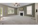 Large carpeted living room with fireplace and lots of natural light at 603 Everglades Dr, Mebane, NC 27302