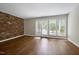 Bright living room with laminate floors and a brick accent wall at 606 Oak Tree Dr, Chapel Hill, NC 27517