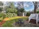 Inviting backyard seating area and shed, with lush landscaping and a well-manicured lawn at 627 New Road, Raleigh, NC 27608
