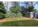 Lush backyard with a well-maintained lawn, complemented by a charming shed and ample greenery at 627 New Road, Raleigh, NC 27608